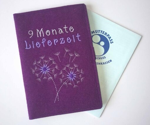 Lila Wollfilzhülle für den Mutterpass mit Pusteblume